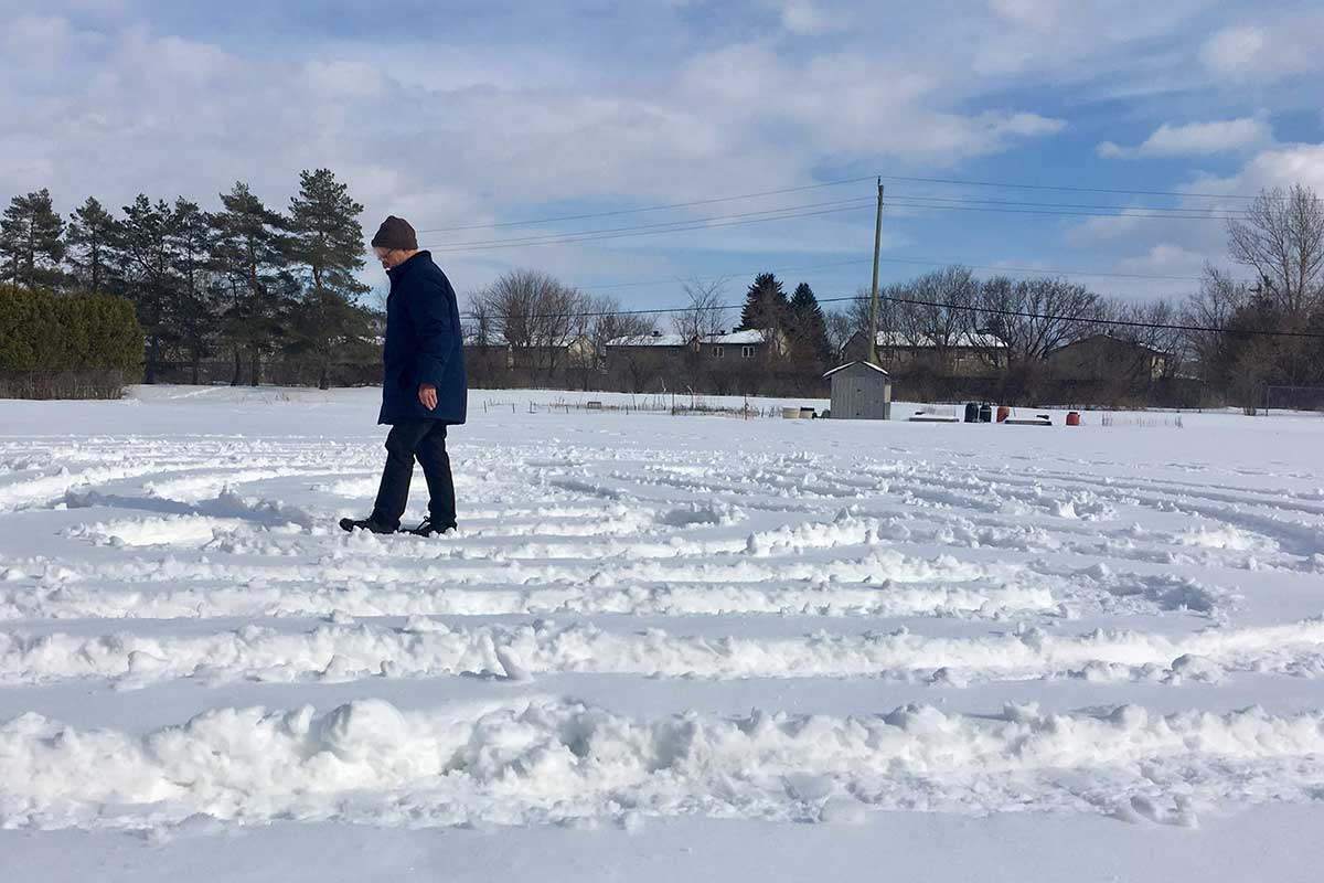 Person walking a labyrinth made of snow