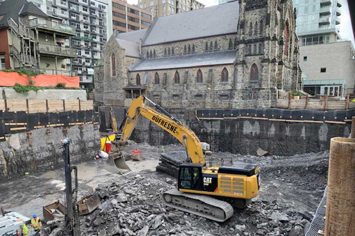 Excavator digging out foundation in front of the Cathedral