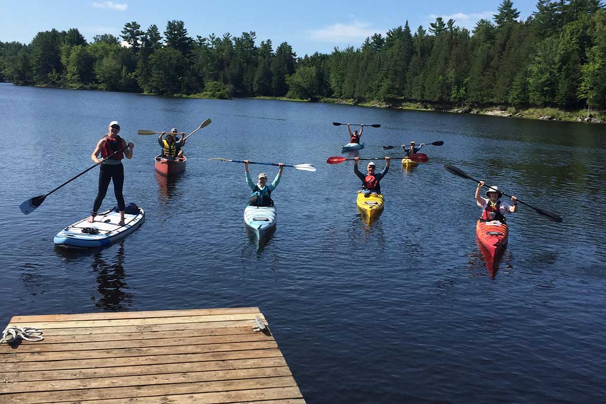 Kayakers raising their paddles in celebration