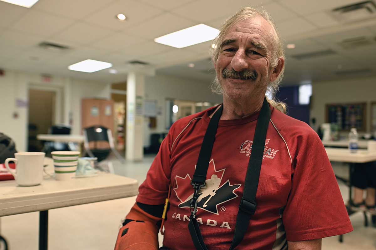 Man in a red shirt and apron smiling
