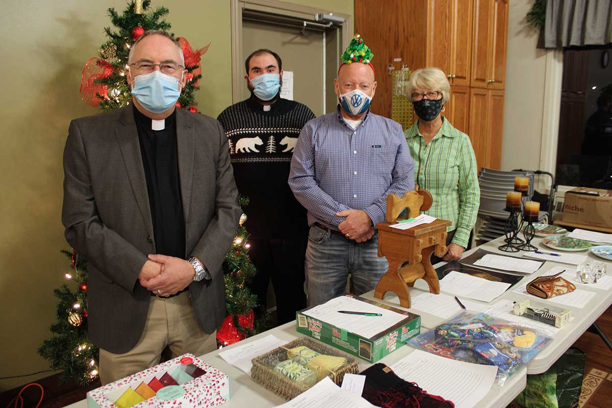 From left: Archdeacon Peter Crosby, the Rev. Adam Brown, auctioneer Mike Cook and organizer Nancy Hallberg are all smiles behind their masks shortly before the live auction portion of the Nov. 27 fundraiser. 