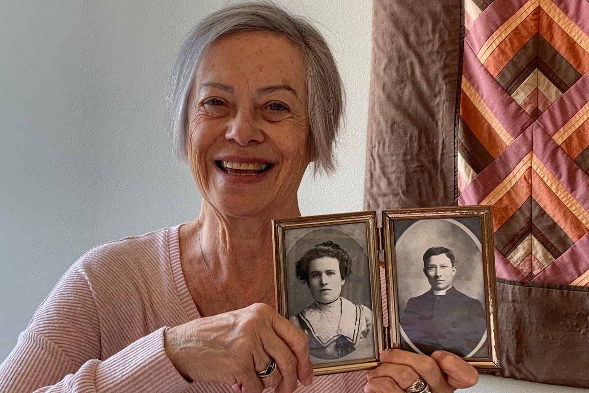 Kathryn Fournier holding black and white photos of her grandparents