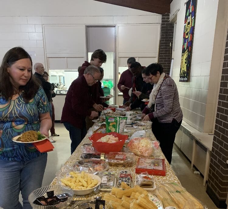 People sampling Asian foods from a buffet in St. Mark's church hall