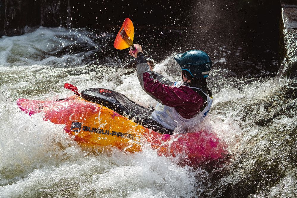 Stock photo of person kayaking in rapids