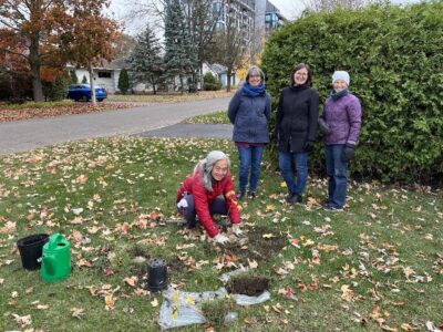 The Rev. Rosemary Parker and parishioners from St. Aidan's plant a tree.