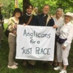 Five people gathered holding a sign that says Anglicans for a Just Peace