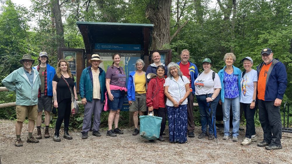 Parishioners from St. John the Evangelist with Louella Tobias pose by a sign at Mud Lake.