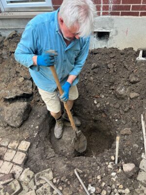 Bishop Shane Parker digging a hole for the foundation of an addition to a home.