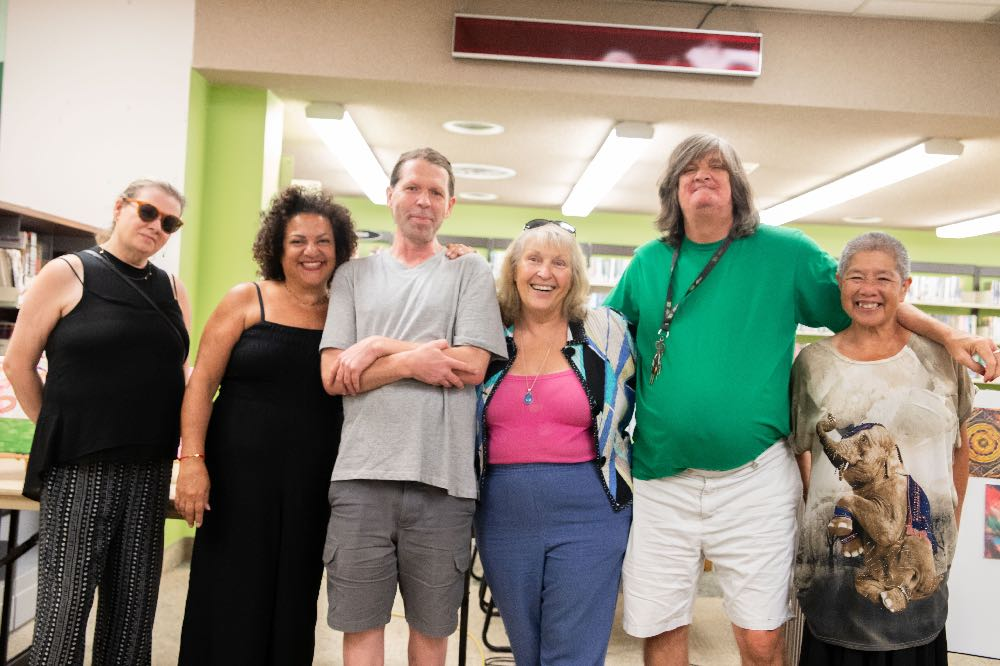 Artists from Belong Ottawa gather at the exhibit at Ottawa Public Library's main branch.