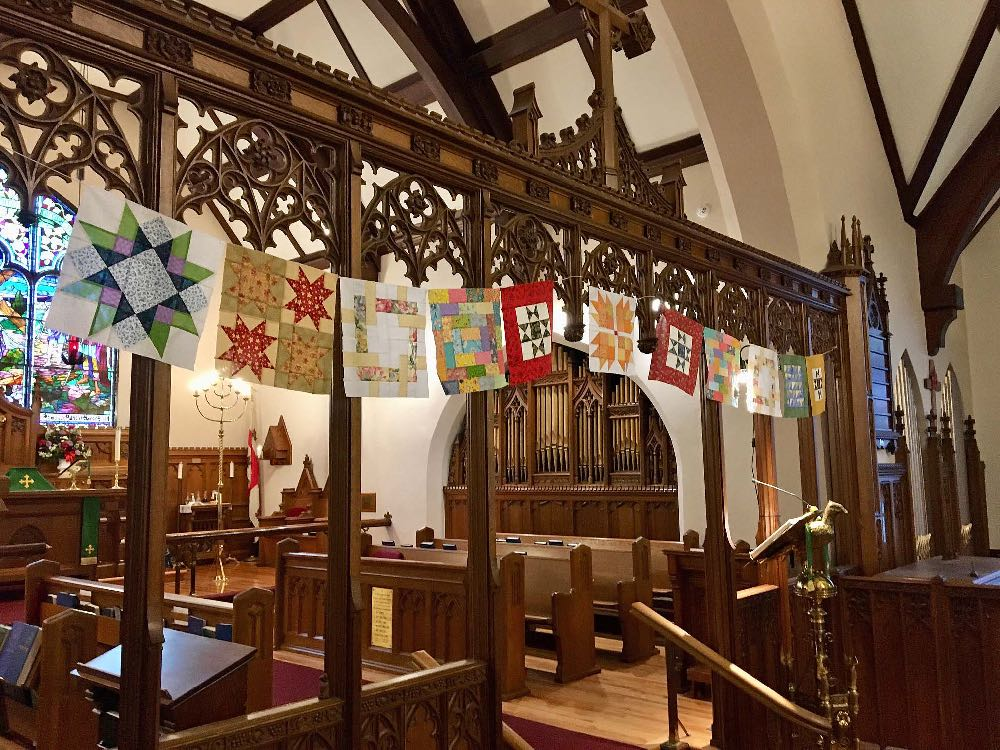 Quilts hang on the rood screen in Holy Trinity Pembroke.