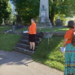 The Rev. Canon Catherine Ascah speaks to St. Bart's parishioners in Beechwood Cemetery.