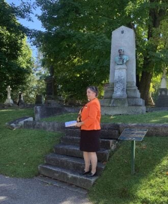 The Rev. Canon Catherine Ascah speaks to St. Bart's parishioners in Beechwood Cemetery.