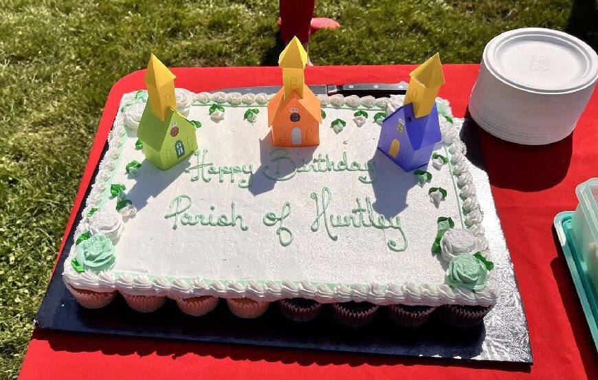 Birthday cake with three brightly coloured miniature churches on top