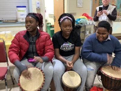 Three teens try out the drums