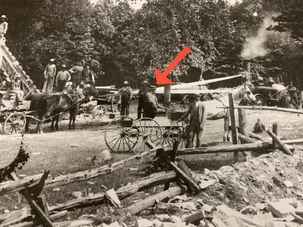 The hired man/chauffeur of Reeve James Code shown in a remarkable 1903 photograph of farmers breaking stone to make gravel for the roads.