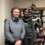 Two women stand by the Christmas tree