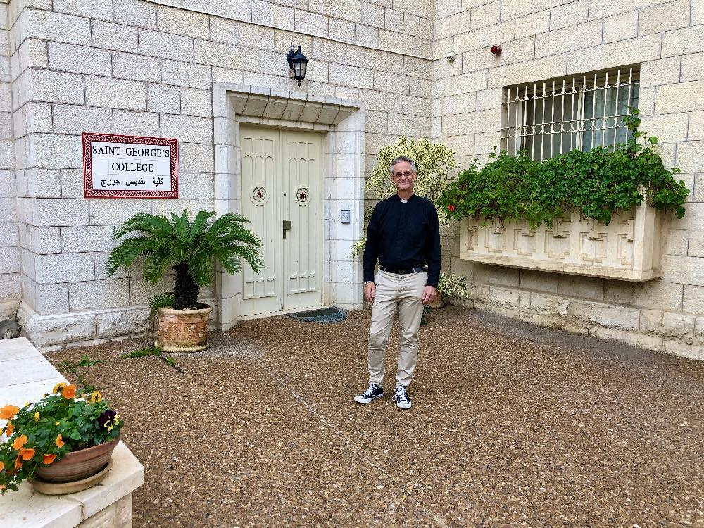 The Very Rev. Richard Sewell stands by the entreance to St. Geroge's College, Jerusalem.