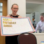 Anna Lapwood holds a birthday card from the audience.