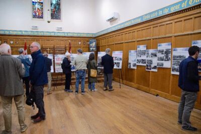 People looking at the poster exhibit at St. John the Evangelist.