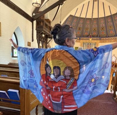 The Rev. Canon Aigah Attagutsiak shows friends the beautiful wrap she is wearing — a gift from the Ottawa Aboriginal Coalition.