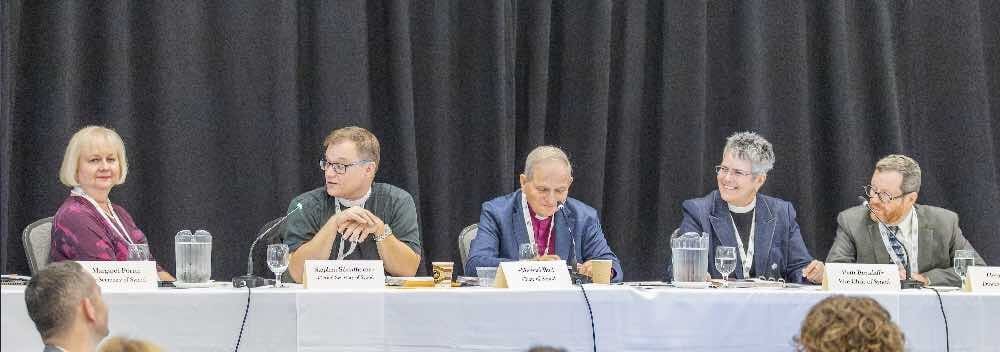 Synod officers sit at the head talbe.