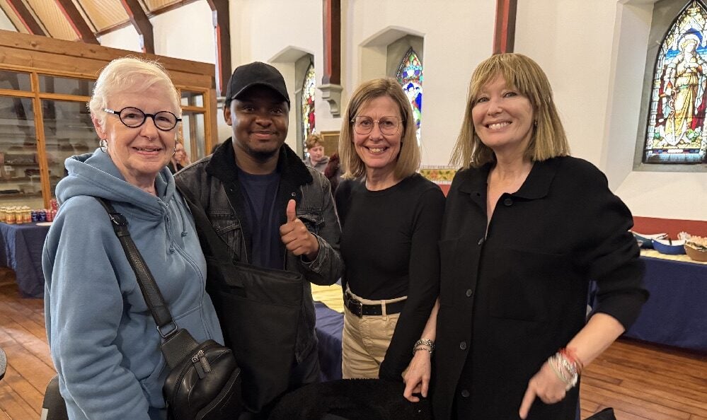 Hussein, a Belong Ottawa staffer, give the thumb's up, enjoying the afternoon's festivities with volunteers (L to R) Judy, Irene and Mary at St. Albans' church.