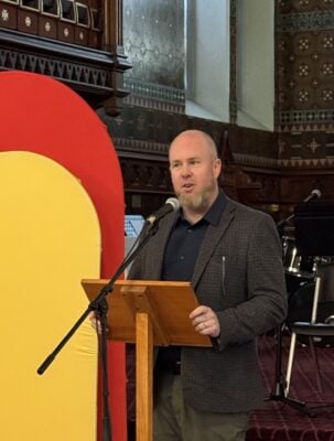 The Rev. Michael Garner speaking at a podium in the historic St. Albans church.