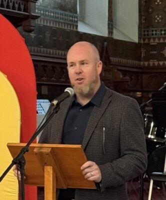 The Rev. Michael Garner speaking at a podium in the historic St. Albans church.