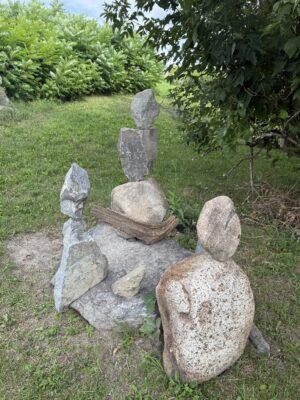 Three sculptures made of rocks arranged verticially.