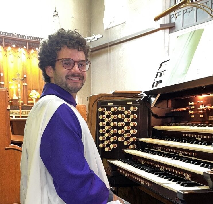 Owen Spicer sits at a pipe organ