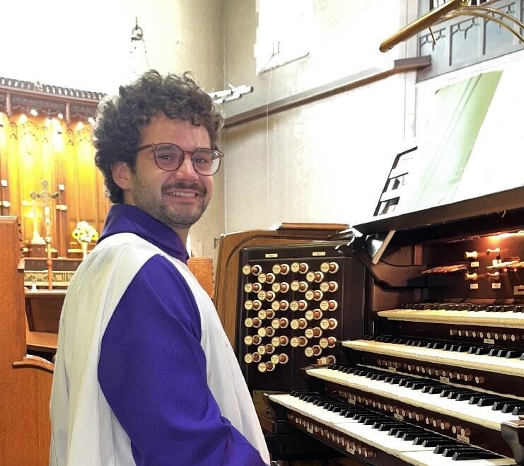 Owen Spicer sits at a pipe organ