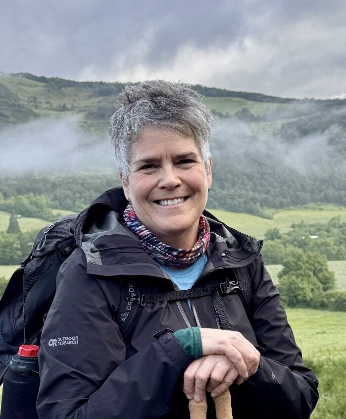 Dean Beth Bretzlaff smiling on the trail with her backpack