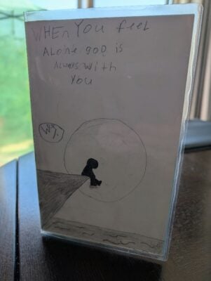 A child's drawing of a person alone on the bow of a ship